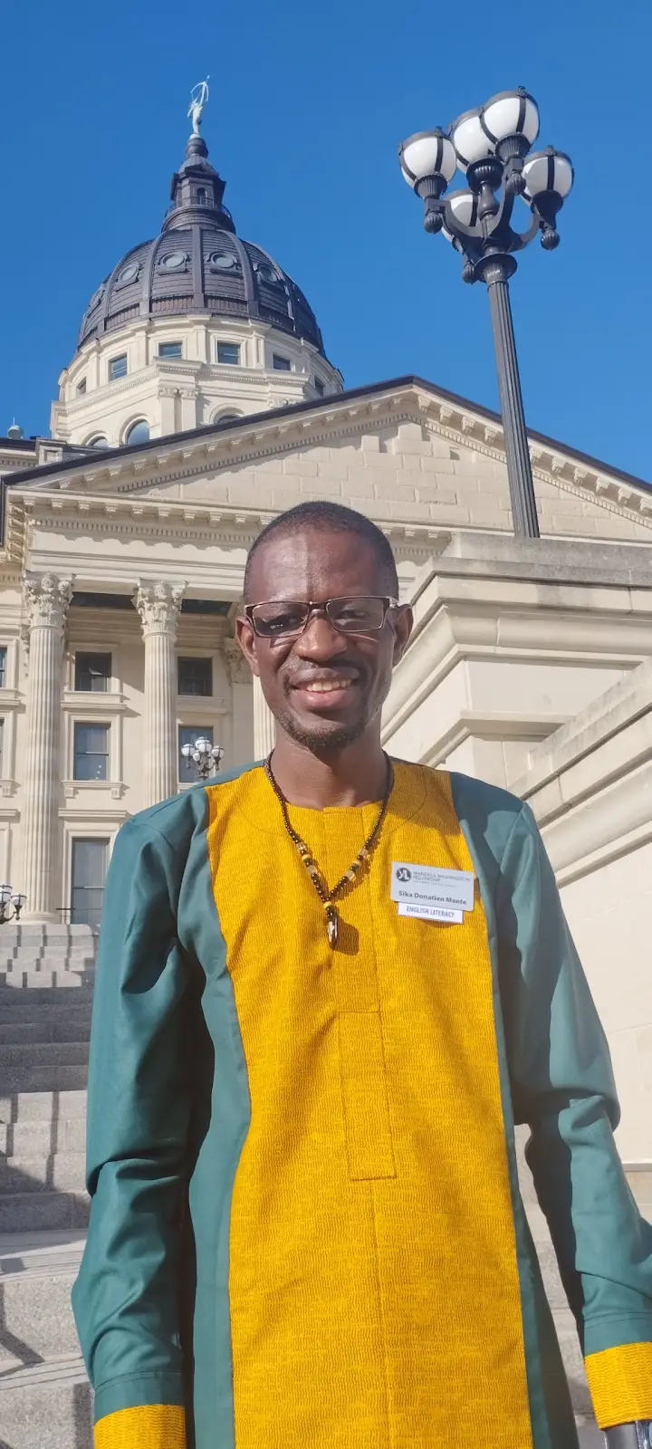 Coach Sika souriant devant le Capitole du Kansas